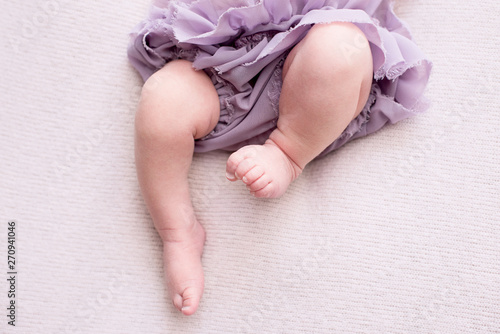 Konstfotografi mother holds the feet of the newborn baby with her hands, fingers on the foot, maternal care, love and family hugs, tenderness