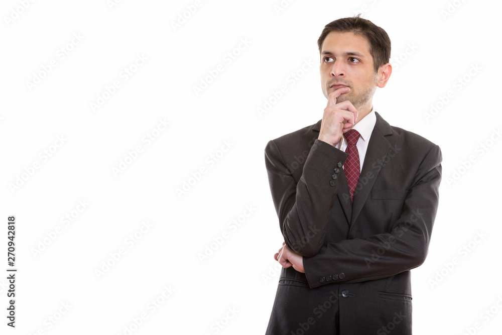 Studio shot of young businessman thinking while looking at dista Studio shot of young businessman thinking while looking at dista