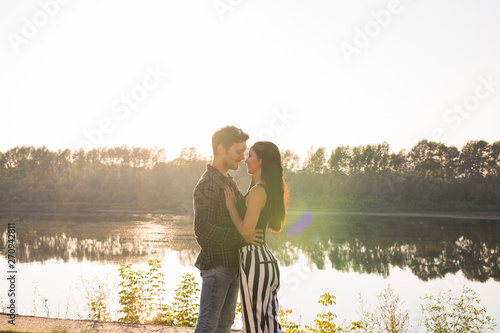 Tenderness, love and nature concept - Beautiful woman and handsome man hugging over water background