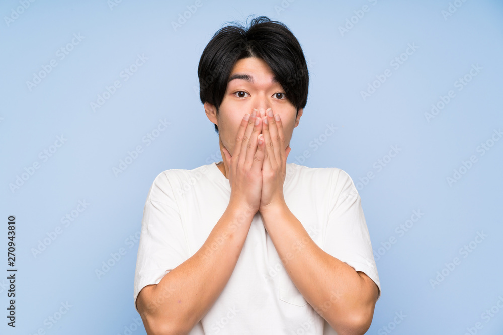 Asian man on isolated blue background with surprise facial expression Asian man on isolated blue background with surprise facial expression