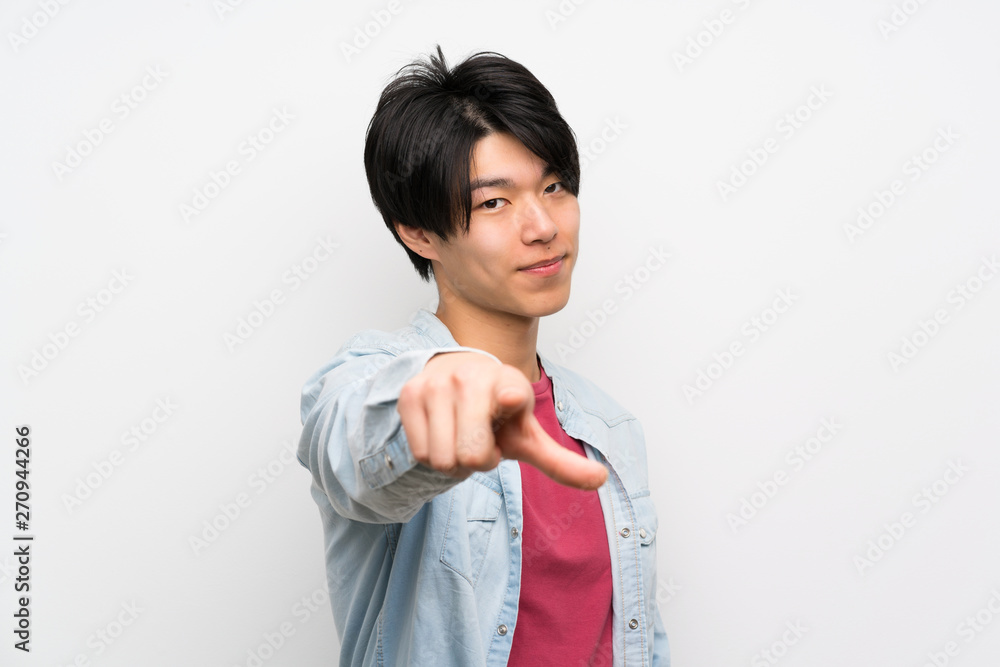 Asian man on isolated white background points finger at you with a confident expression Asian man on isolated white background points finger at you with a confident expression