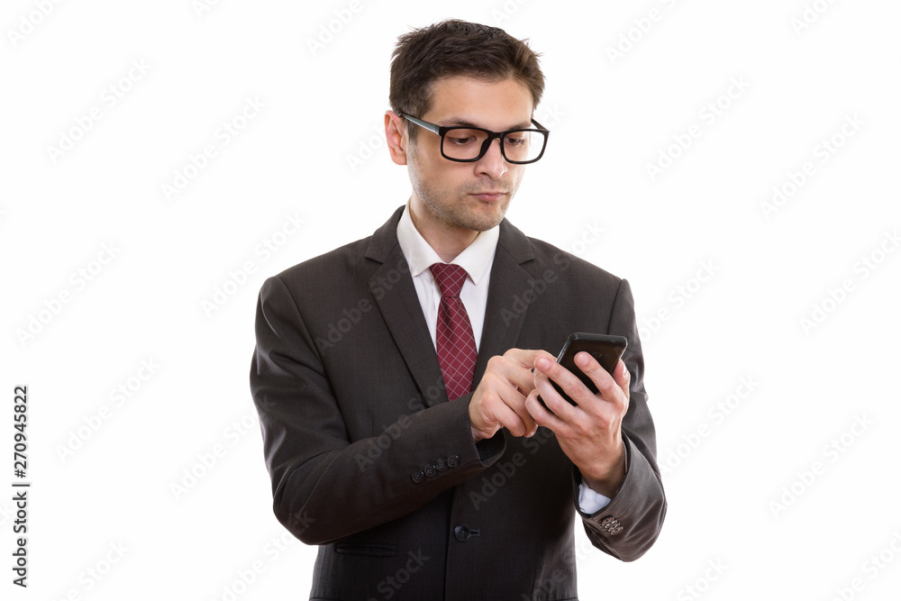 Studio shot of young businessman wearing eyeglasses while using Studio shot of young businessman wearing eyeglasses while using