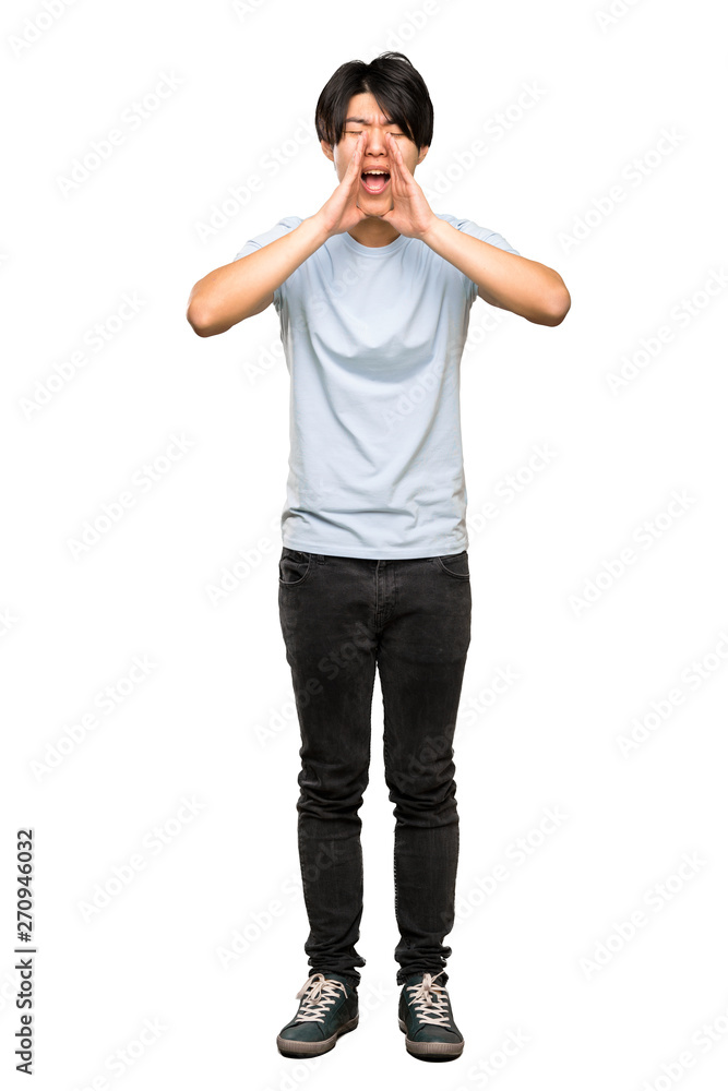 A full-length shot of a Asian man with blue shirt shouting and announcing something over isolated white background A full-length shot of a Asian man with blue shirt shouting and announcing something over isolated white background