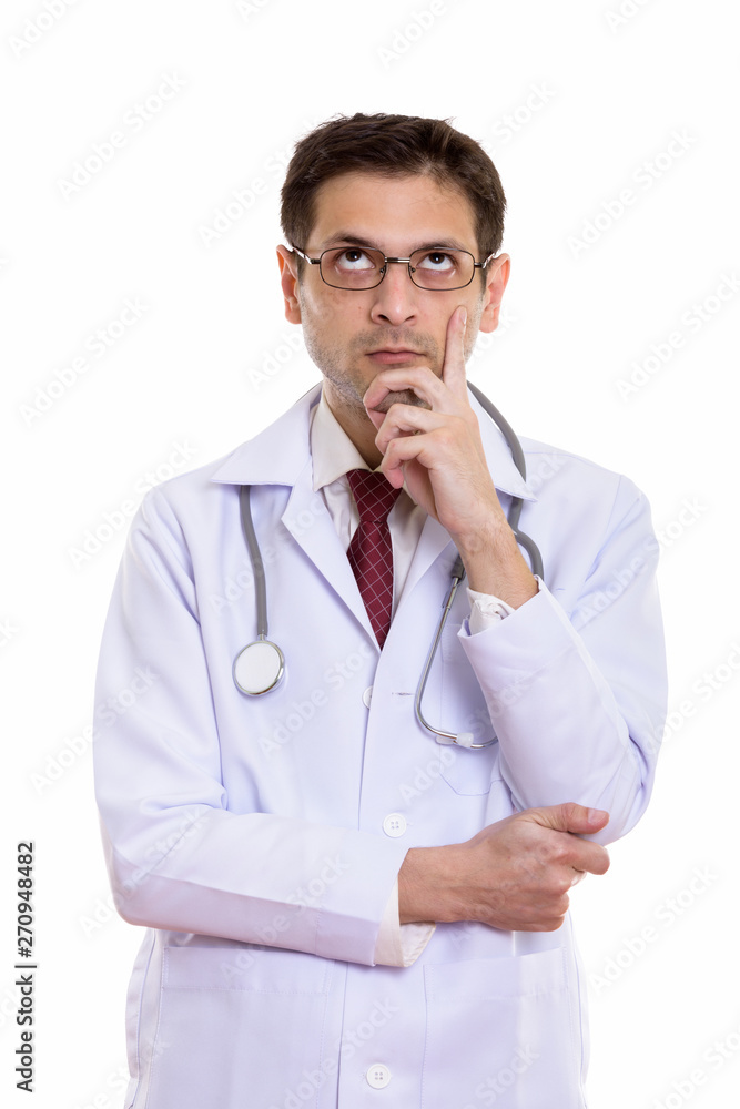 Studio shot of young man doctor wearing eyeglasses while thinkin Studio shot of young man doctor wearing eyeglasses while thinkin