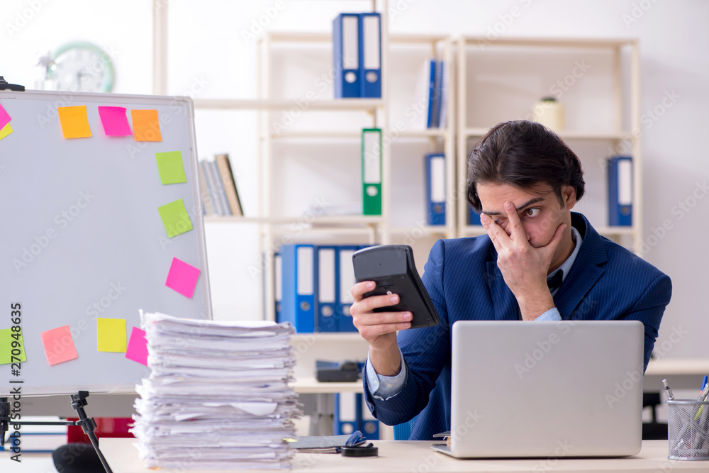 Young male employee unhappy with excessive work Young male employee unhappy with excessive work