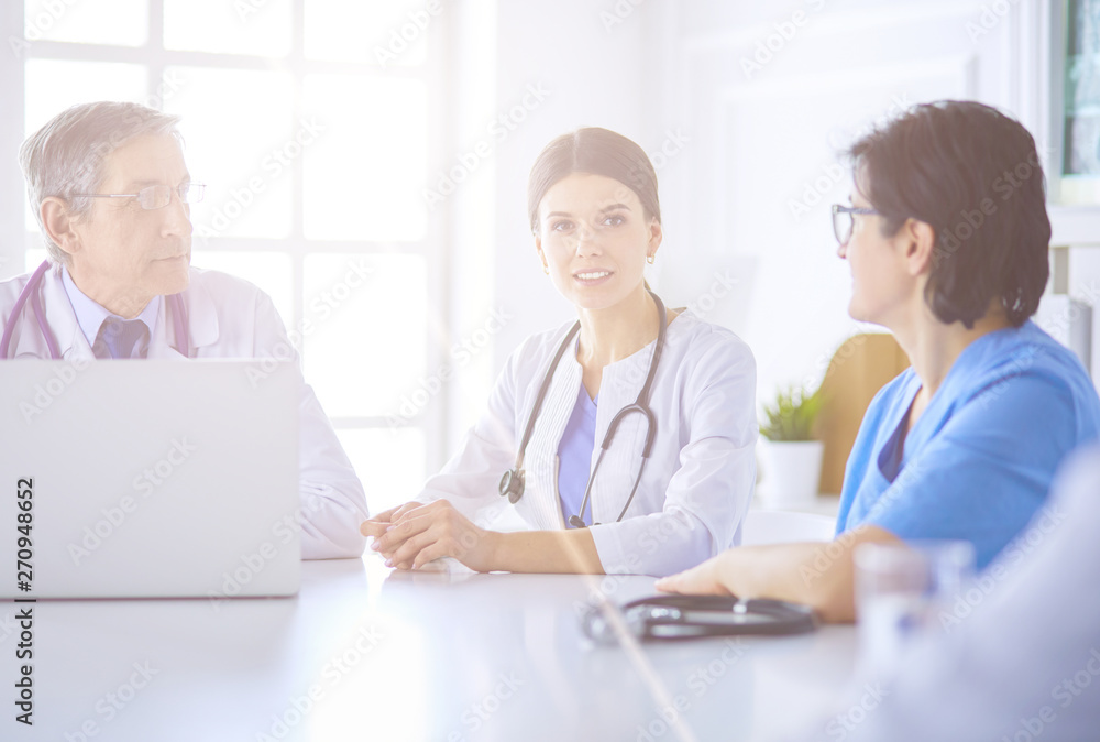 Doctors consulting with each other in a hospital conference room Doctors consulting with each other in a hospital conference room