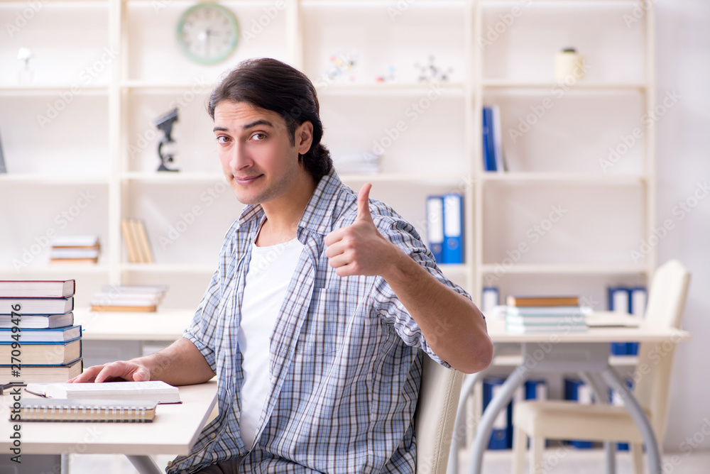 Young male student preparing for exams at home 