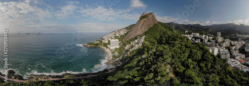Aerial sunrise panorama of Rio de Janeiro Two Brothers mountain peaks with the rich Leblon neighbourhood on the right and Vidigal shantytown on the steep and coastal side where a bicycle lane passes photo