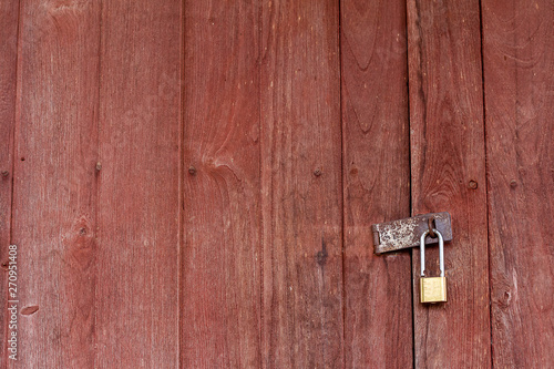 The background is a wooden door, the old house has an iron hinge and a key to lock the door.