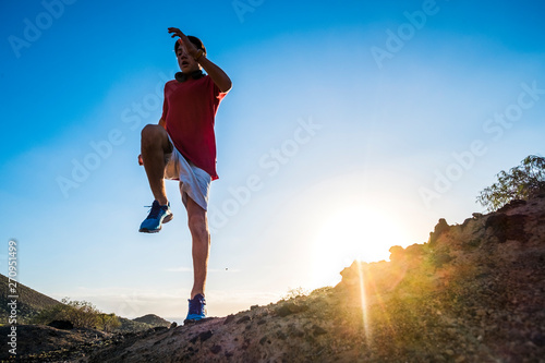 Fototapeta Naklejka Na Ścianę i Meble -  teenager running alone at the mountain with sunset - man jogging - positive vibes - jumping