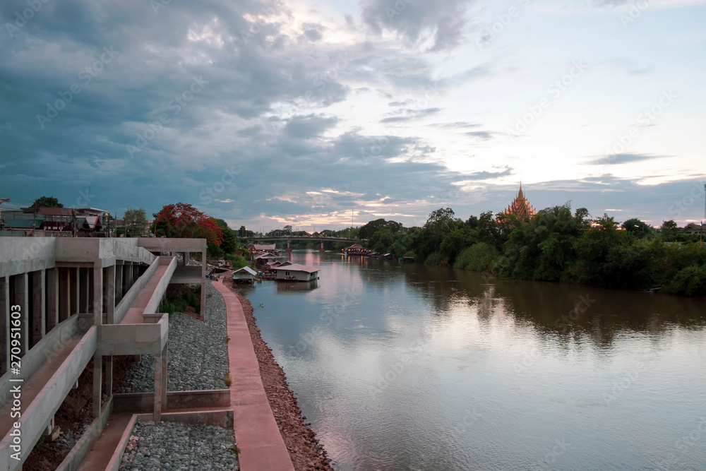 Fototapeta premium River view in urban city with house boat, bridge and temple before the storm coming.