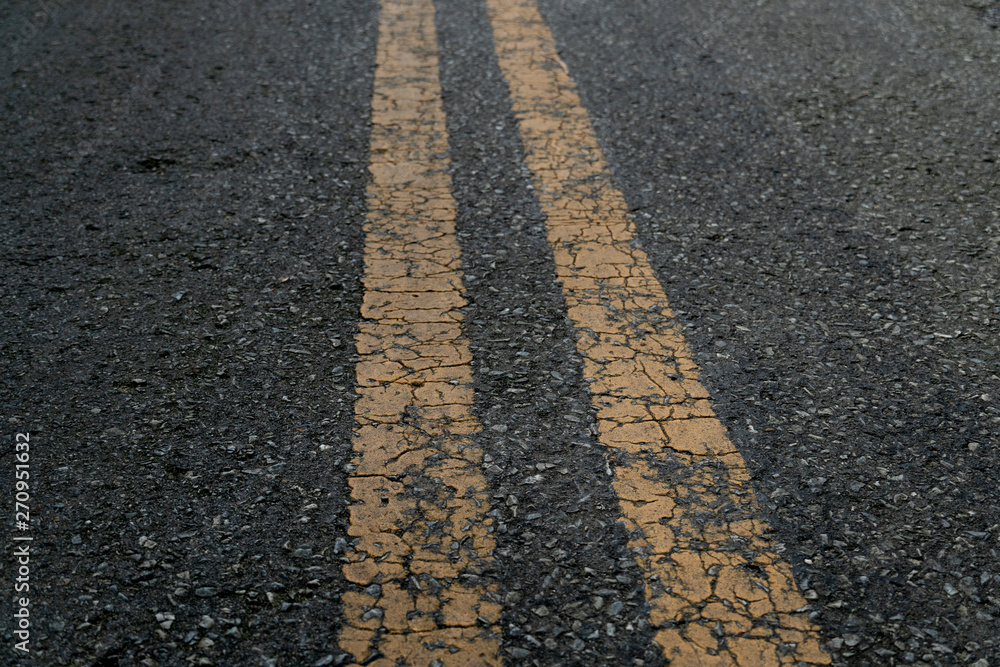 Obraz premium Background of two yellow line crack on asphalt road.