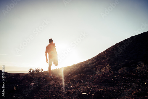 teenager stretching in mountains at the sunset - runner life and sportive concept - outdoor lifestyle
