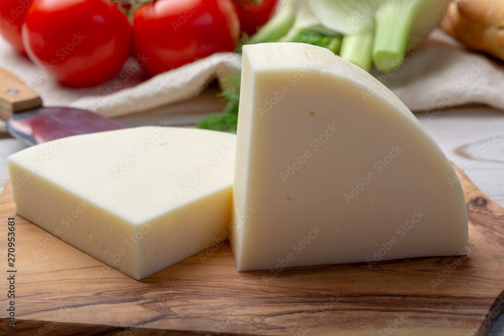 Italian cheese, Provolone dolce cow cheese from Cremona served with olive bread and tomatoes Italian cheese, Provolone dolce cow cheese from Cremona served with olive bread and tomatoes
