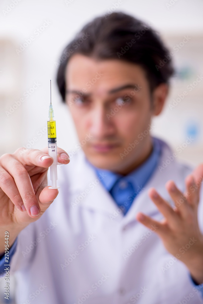 Young male chemist experimenting in lab Young male chemist experimenting in lab