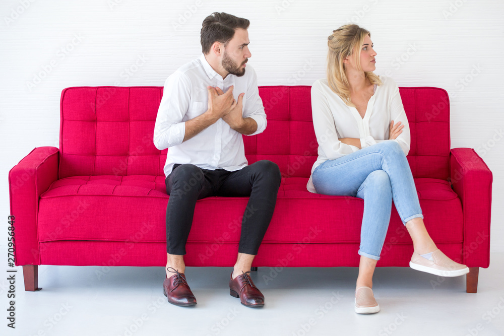 couple in love girlfriend and boyfriend having quarrel on red sofa at home, indoors . Upset couple in love girlfriend and boyfriend having quarrel on red sofa at home, indoors . Upset