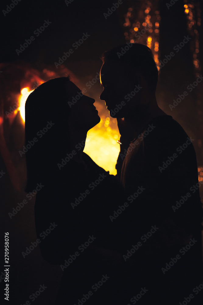 silhouette couple in fashionable clothes on a shiny background