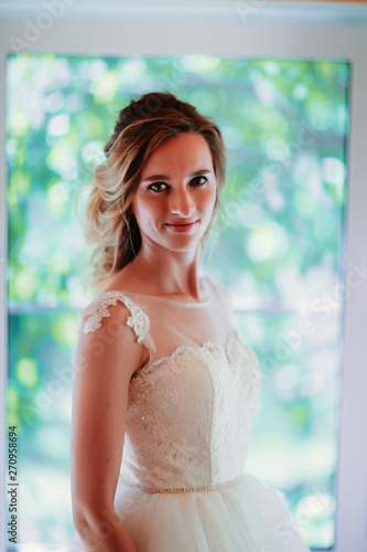 Beautiful young bride on blurred color background