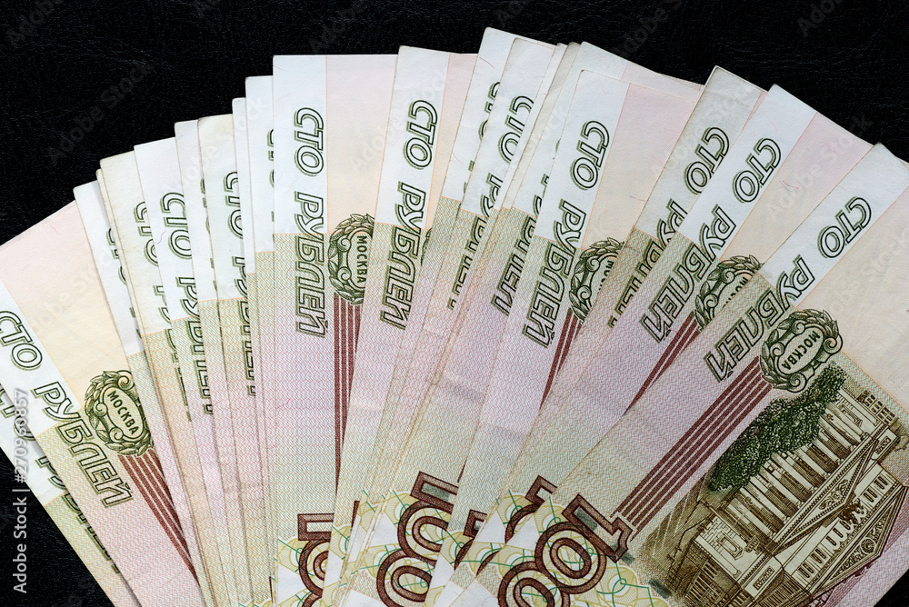A stack of Russian banknotes of a hundred rubles on a dark background close up A stack of Russian banknotes of a hundred rubles on a dark background close up