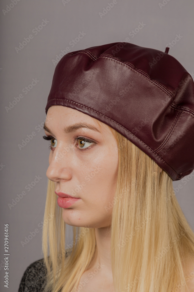 Portrait of a beautiful young girl in a stylish headdress with natural makeup on a gray background. Portrait of a beautiful young girl in a stylish headdress with natural makeup on a gray background.