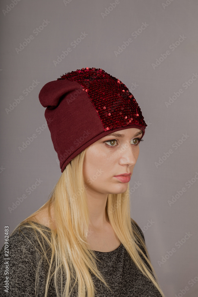 Portrait of a beautiful young girl in a stylish headdress with natural makeup on a gray background. Portrait of a beautiful young girl in a stylish headdress with natural makeup on a gray background.