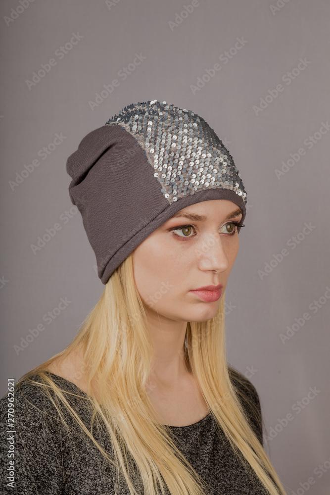 Portrait of a beautiful young girl in a stylish headdress with natural makeup on a gray background. Portrait of a beautiful young girl in a stylish headdress with natural makeup on a gray background.