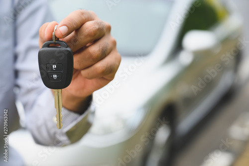 Businessman giving a car key. Getting new car concept.