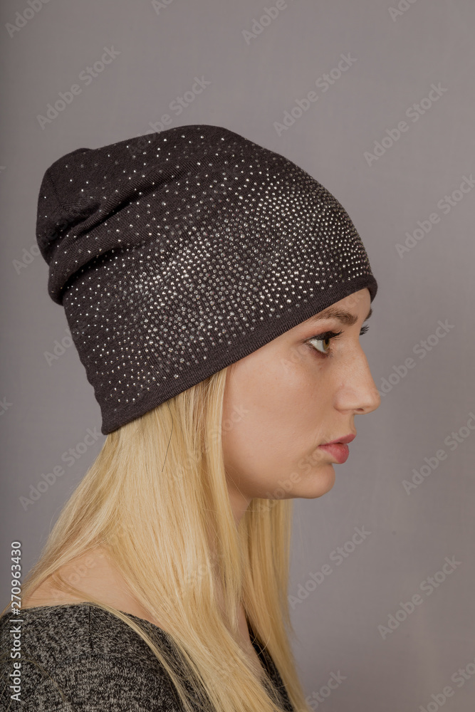 Portrait of a beautiful young girl in a stylish headdress with natural makeup on a gray background. Portrait of a beautiful young girl in a stylish headdress with natural makeup on a gray background.