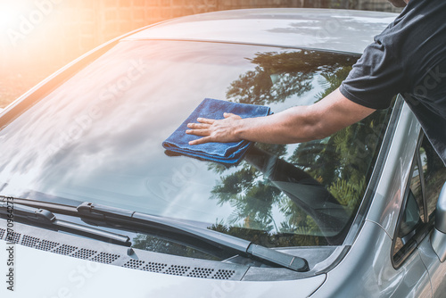 man cleaning car with microfiber cloth photo