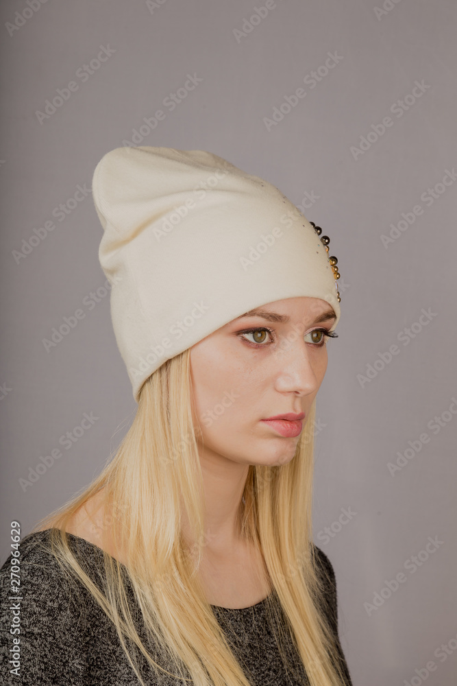 Portrait of a beautiful young girl in a stylish headdress with natural makeup on a gray background. Portrait of a beautiful young girl in a stylish headdress with natural makeup on a gray background.