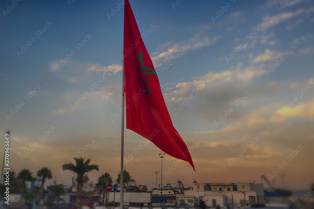 Fototapeta premium The Moroccan national flag with the background of the port of Tangier