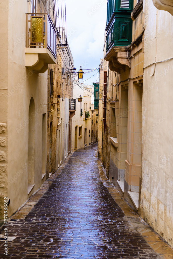 Fototapeta Wet, narrow, cobbled streets in Victoria, Gozo, Malta following a heavy rain storm.