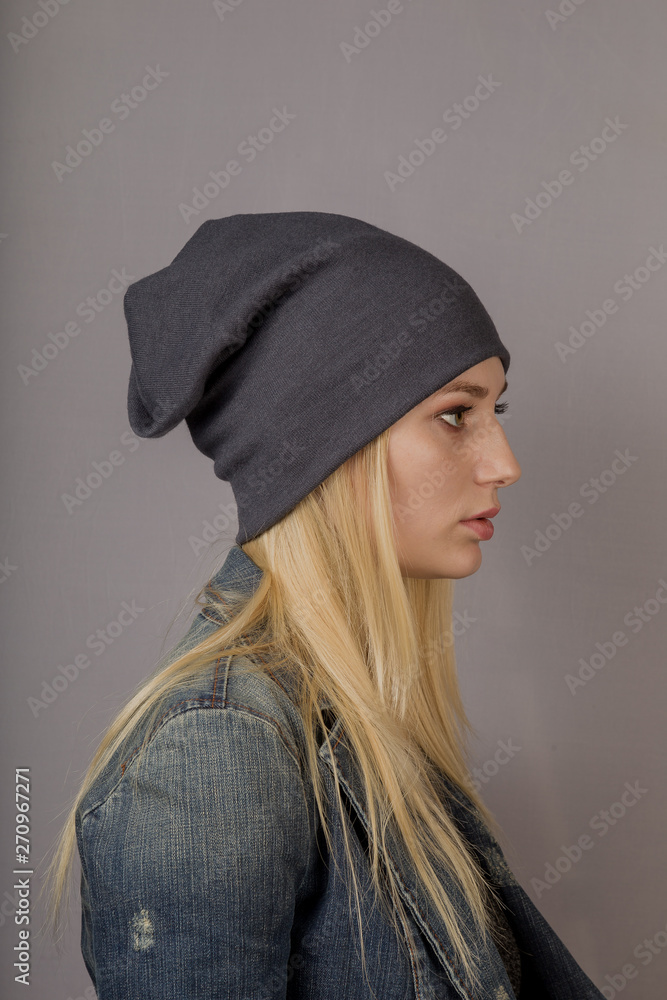 Portrait of a beautiful young girl in a stylish headdress with natural makeup on a gray background. Portrait of a beautiful young girl in a stylish headdress with natural makeup on a gray background.