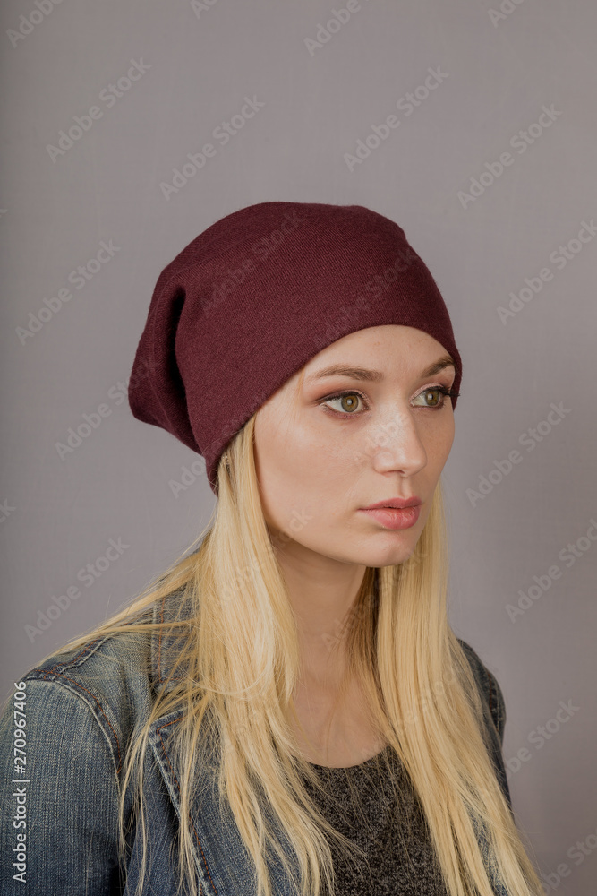 Portrait of a beautiful young girl in a stylish headdress with natural makeup on a gray background. Portrait of a beautiful young girl in a stylish headdress with natural makeup on a gray background.