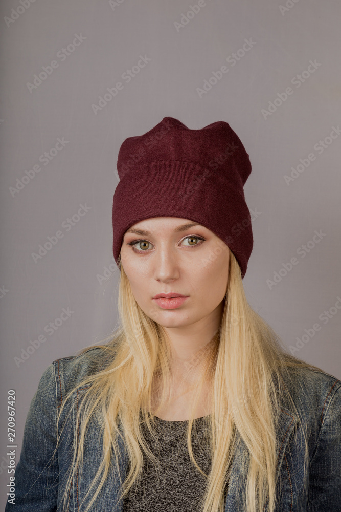 Portrait of a beautiful young girl in a stylish headdress with natural makeup on a gray background. Portrait of a beautiful young girl in a stylish headdress with natural makeup on a gray background.