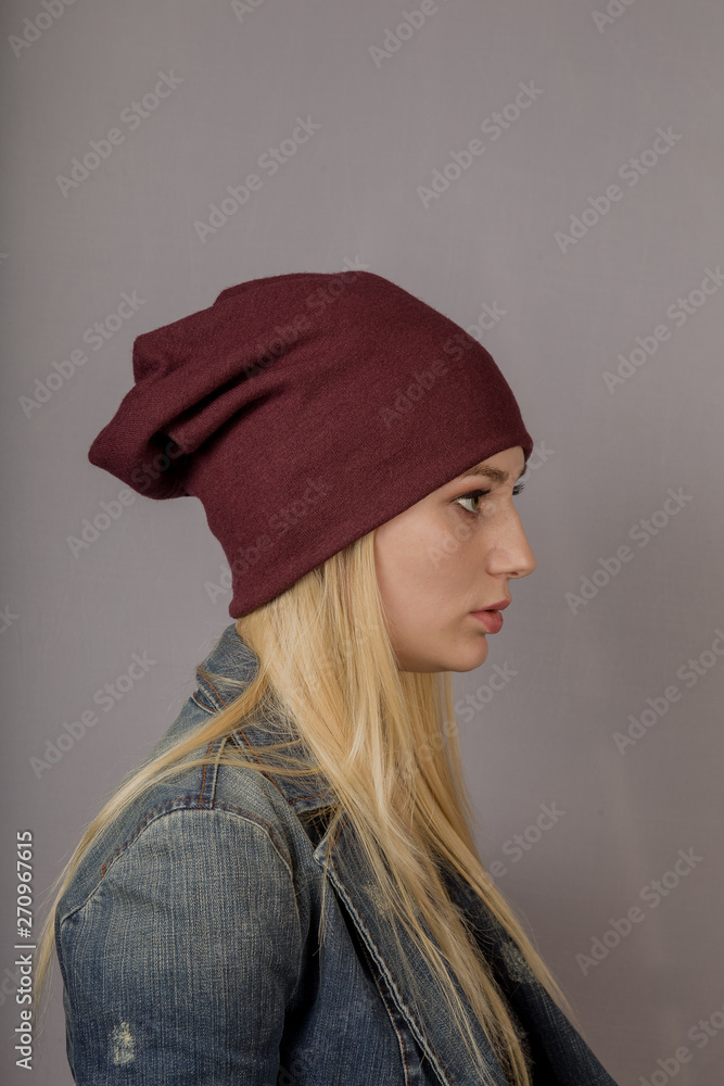 Portrait of a beautiful young girl in a stylish headdress with natural makeup on a gray background. Portrait of a beautiful young girl in a stylish headdress with natural makeup on a gray background.