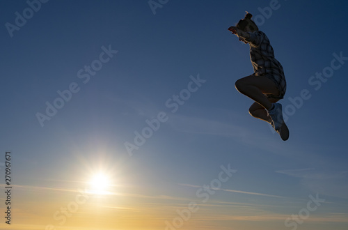 girl doing sports with the sun in the background, celebrating freedom and success © poliki