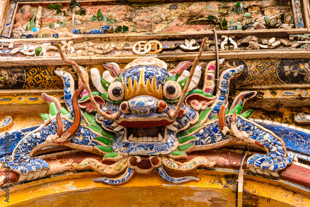 An ornate ceramic mosiac Chinese Lion above an arch in Hoàng thành (Imperial City) a walled citadel built in 1804 in Hue, Vietnam.