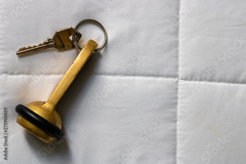 Hotel key laying on the white bed sheets top view - Image