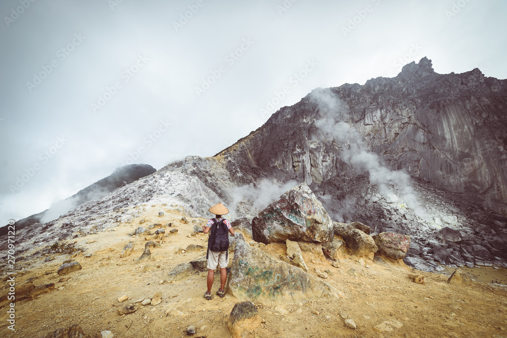 Sibayak volcano, active caldera steaming, famous travel destination natural landmark and tourist attraction in Berastagi Sumatra Indonesia. Tourist looking at view, traveling people, toned.