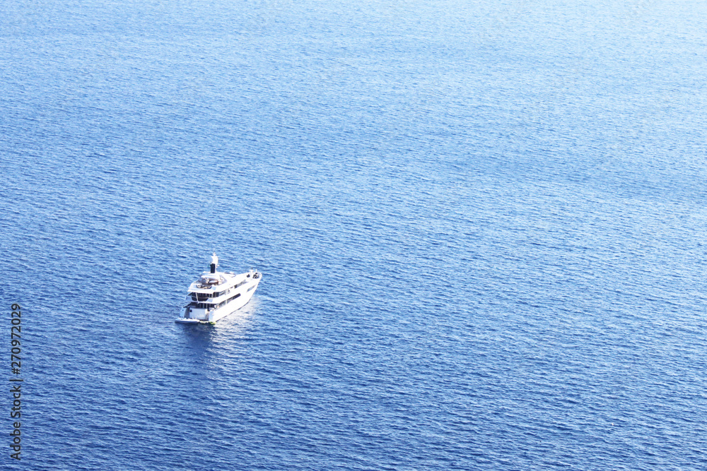 Aerial view to large luxury yacht against blue sea in tropical summer climate