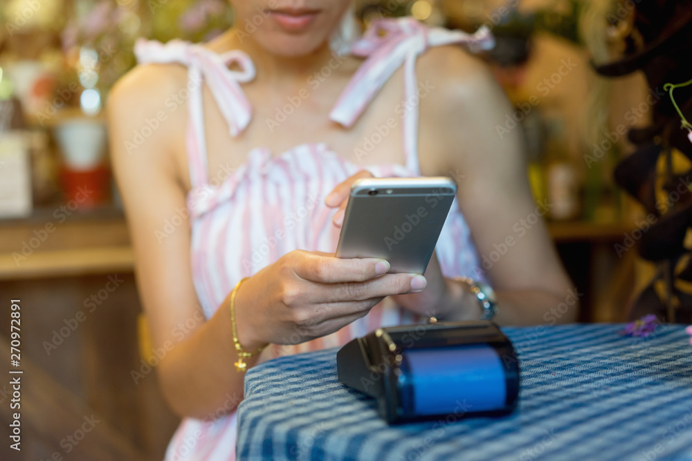 close up customer woman hand using mobile phone for paying bill by payment machine to at table in the cafe , contactless payment concept close up customer woman hand using mobile phone for paying bill by payment machine to at table in the cafe , contactless payment concept