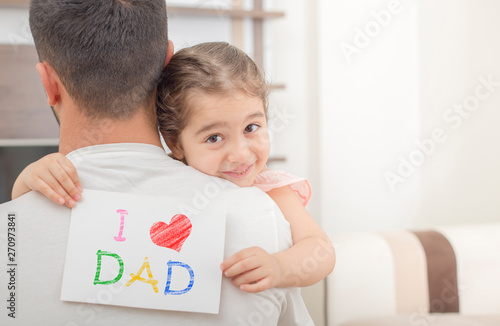 girl shows love dad card on her dad's shoulder