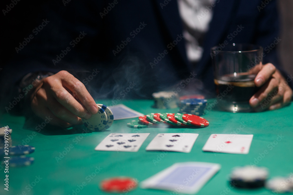 professional poker game. Green poker table with two games. poker player makes a bet by throwing chips on the table professional poker game. Green poker table with two games. poker player makes a bet by throwing chips on the table