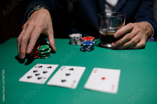 professional poker game. Green poker table with two games. poker player makes a bet by throwing chips on the table