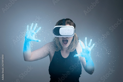 Girl using VR gadget with hands turning into ice in a virtual cyber simulator
