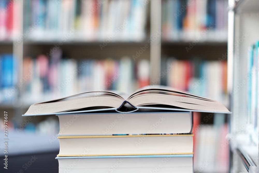 Open book on a stack of books in a library. Open book on a stack of books in a library.
