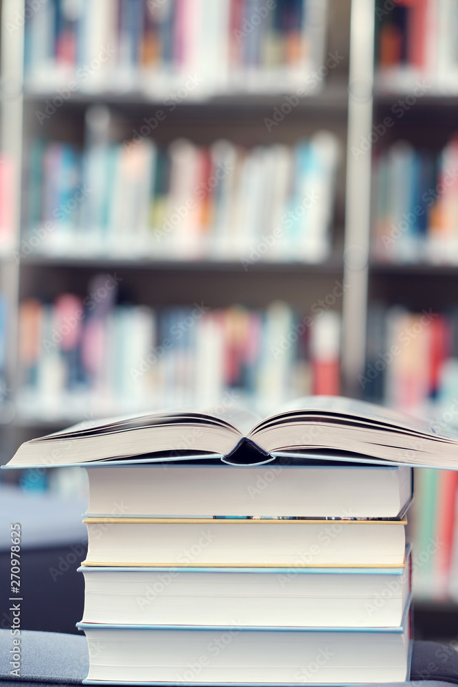 Open book on stack of books in a library. Open book on stack of books in a library.