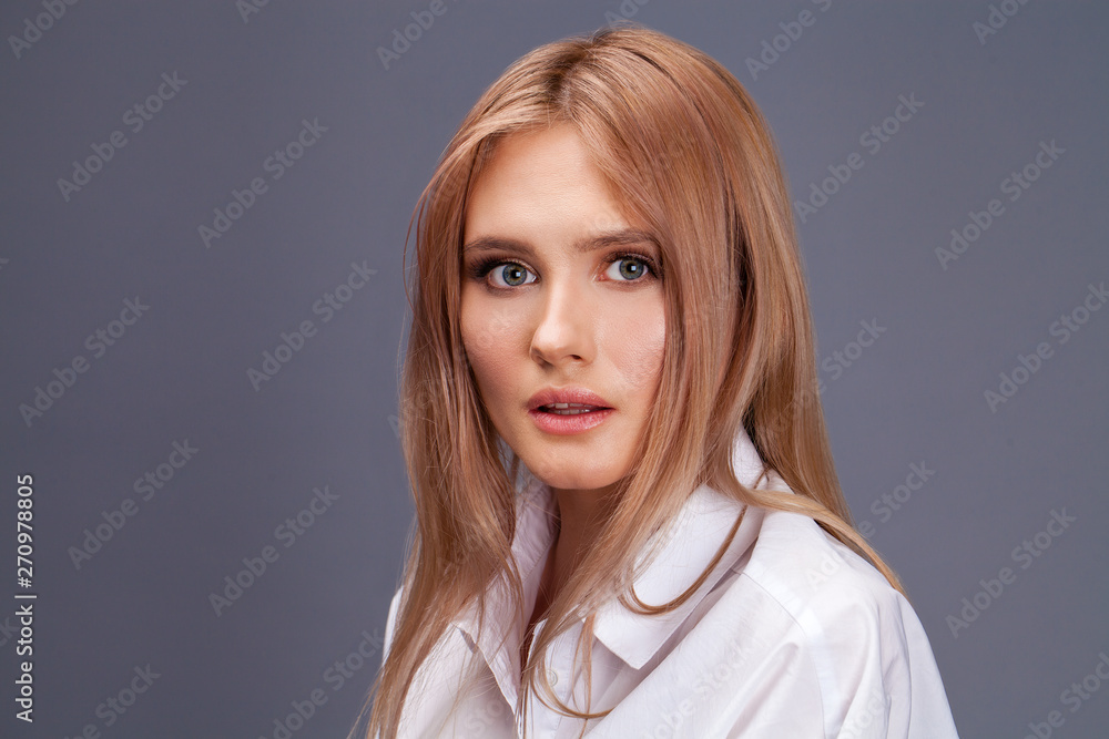 Closeup portrait of a young beautiful blonde woman in a white shirt Closeup portrait of a young beautiful blonde woman in a white shirt