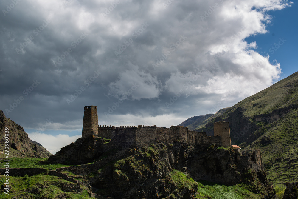 medieval fortress on a rock under a stormy sky